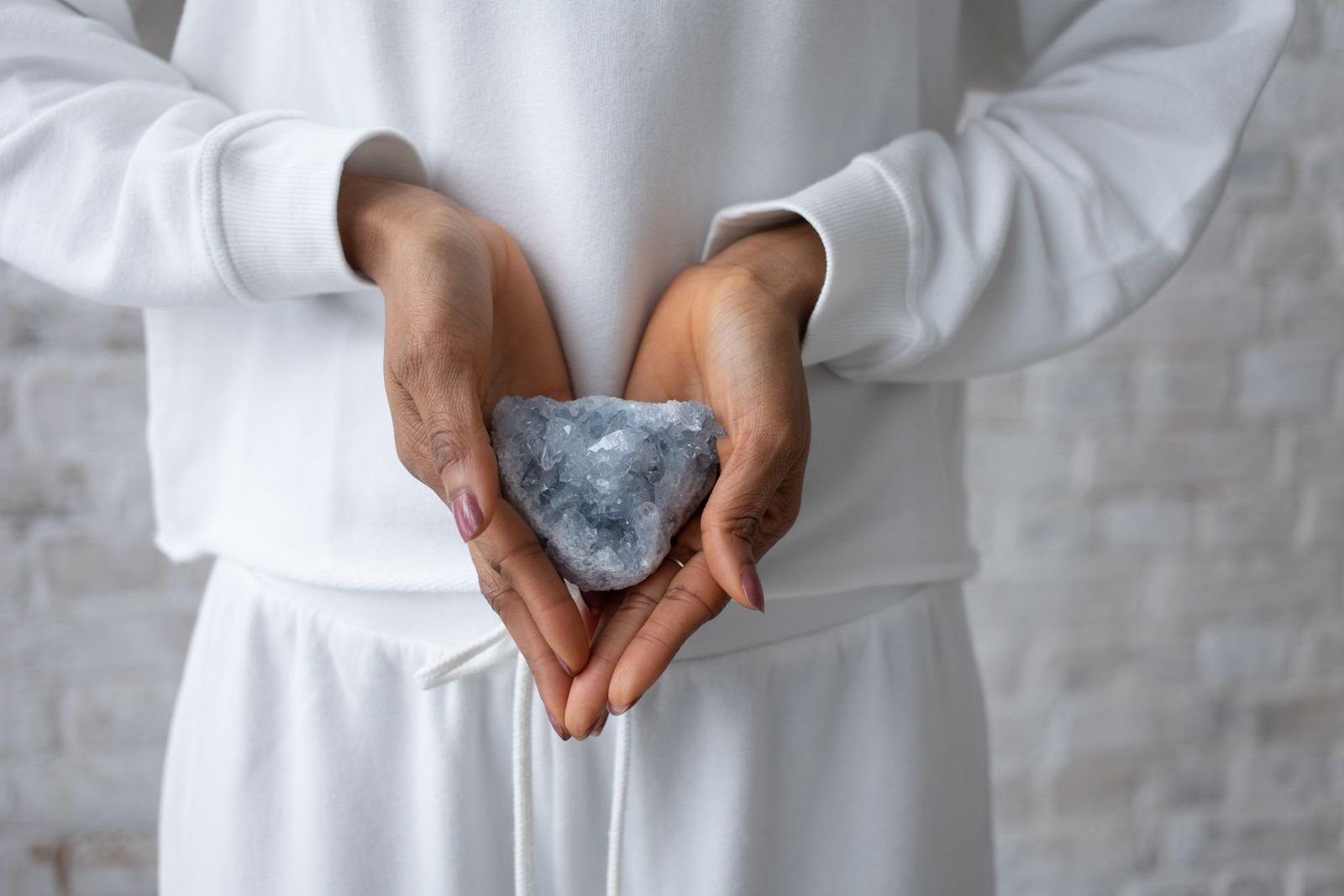 Celestite crystal haath mein pakda hua
