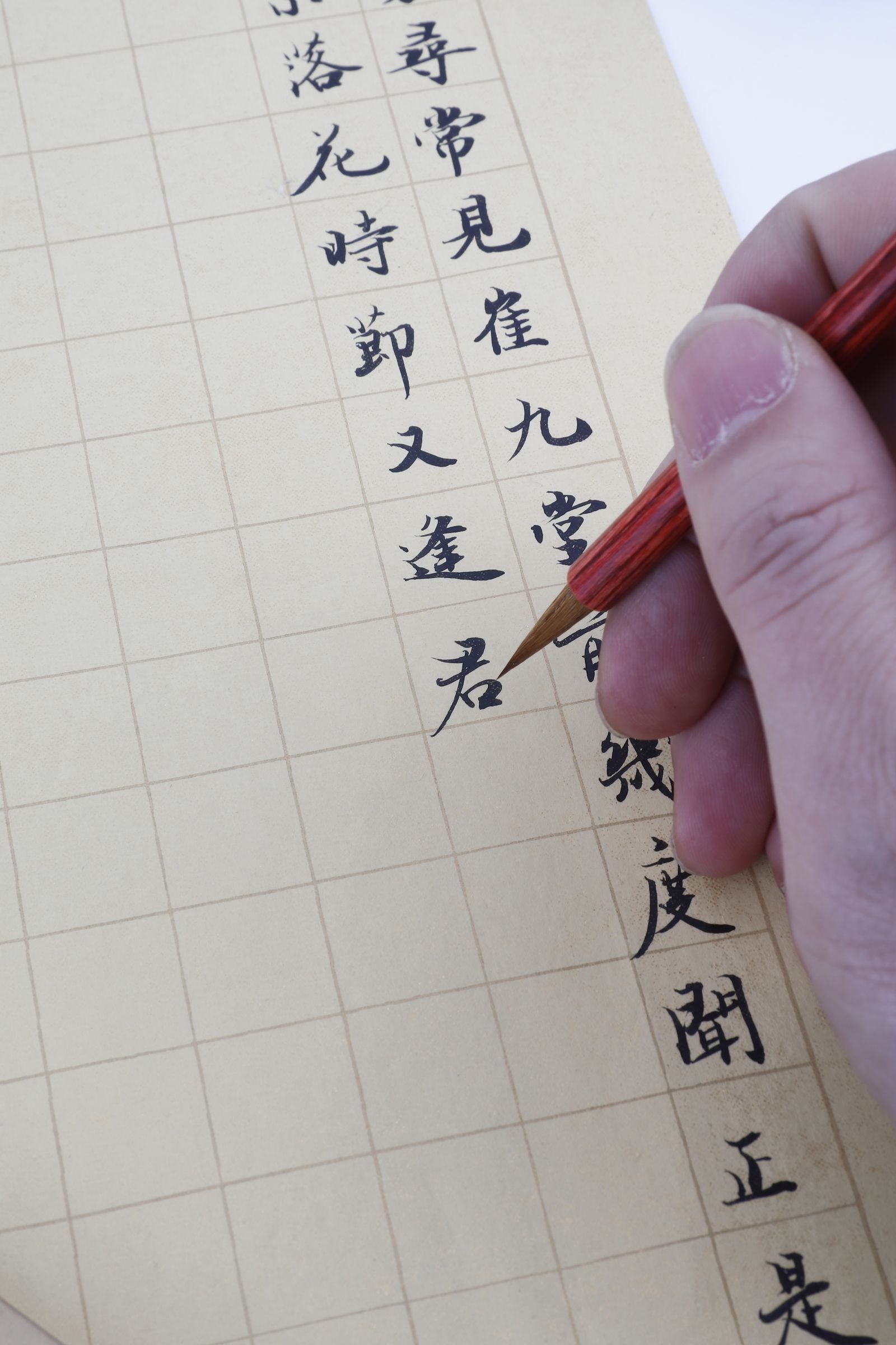 Hath se paramparik calligraphy likhte hue grid paper par - dohrav ka pratik