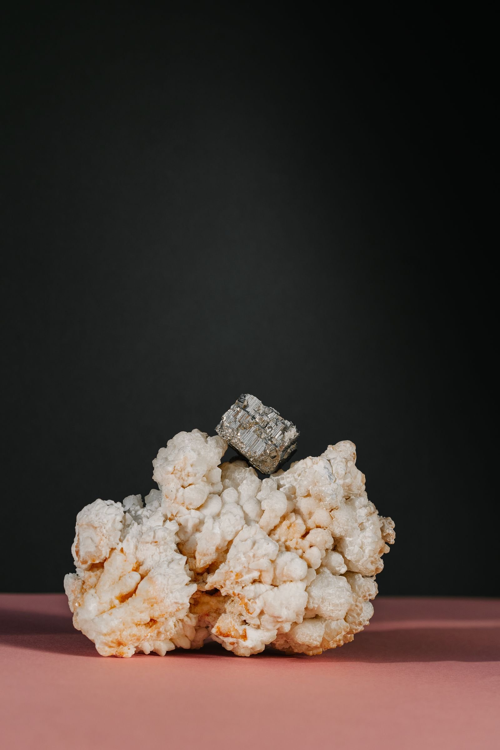 Pyrite crystal calcite ke saath dark background par