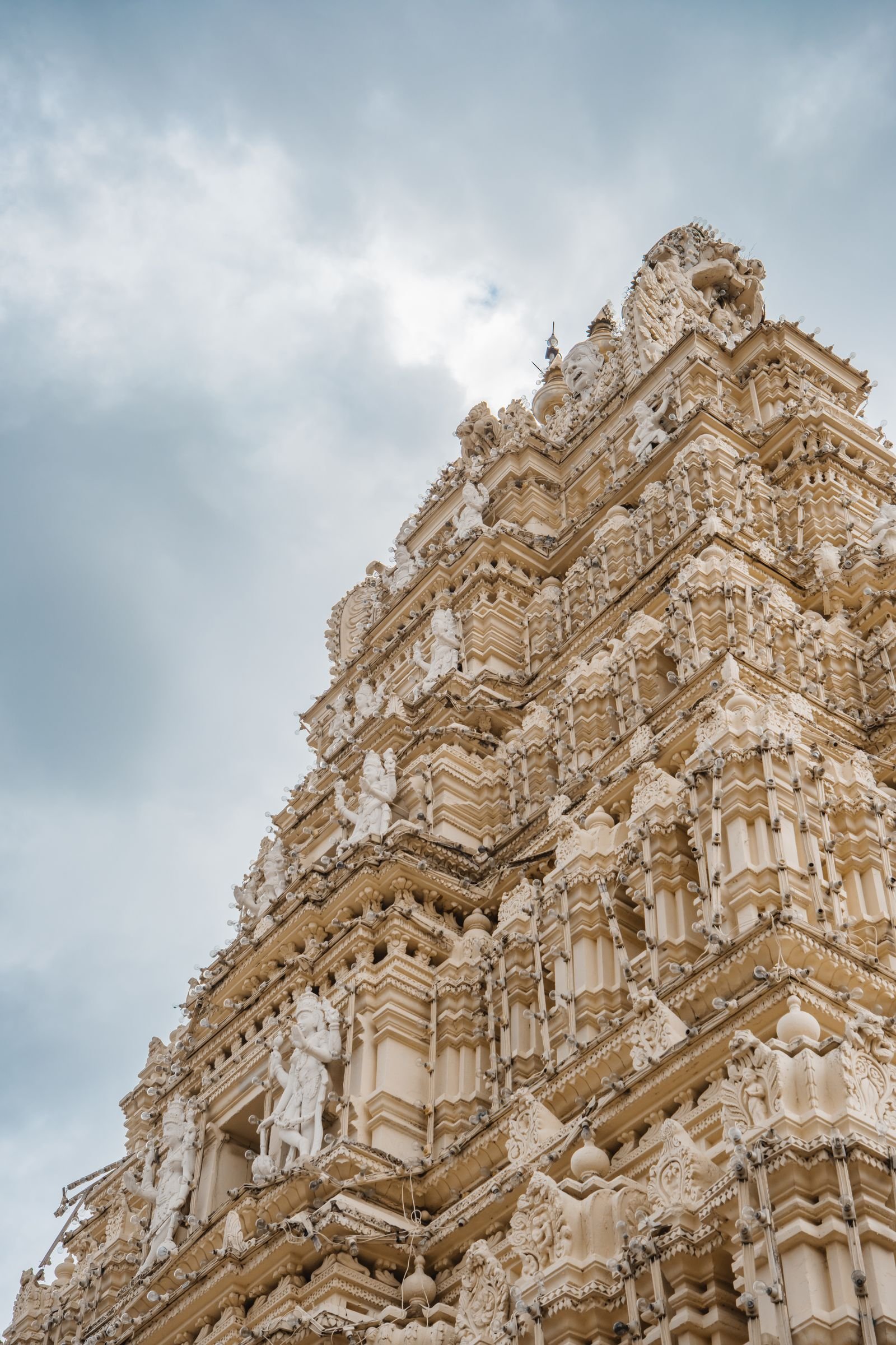 मैसूरु के दक्षिण भारतीय मंदिर गोपुरम की देवताओं से सजी नक्काशी — ४५ वास्तु देवताओं का प्रतीक