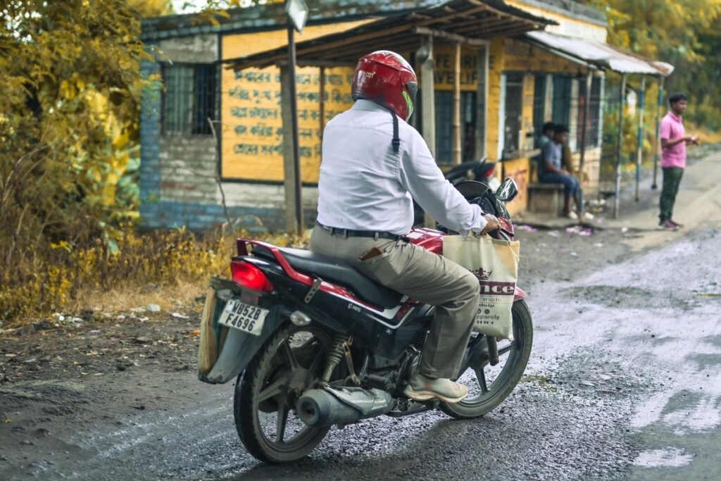 ग्रामीण भारत में हेलमेट पहने मोटरसाइकिल चालक — दुर्घटना सुरक्षा