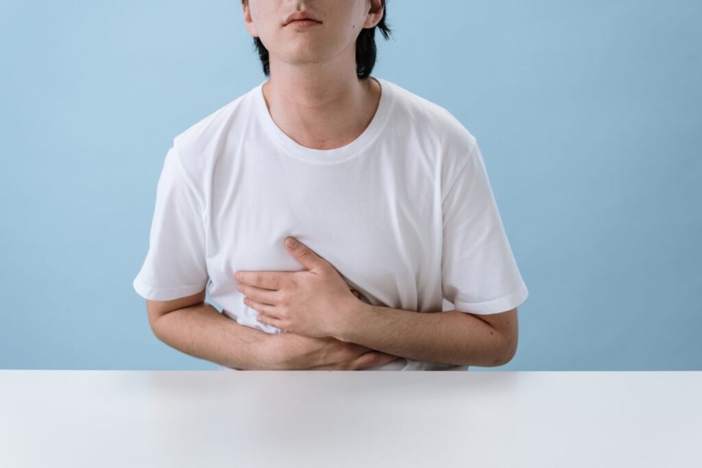 पेट पकड़े दर्द में खड़ा व्यक्ति - पेट संबंधी समस्या का ज्योतिषीय विश्लेषण